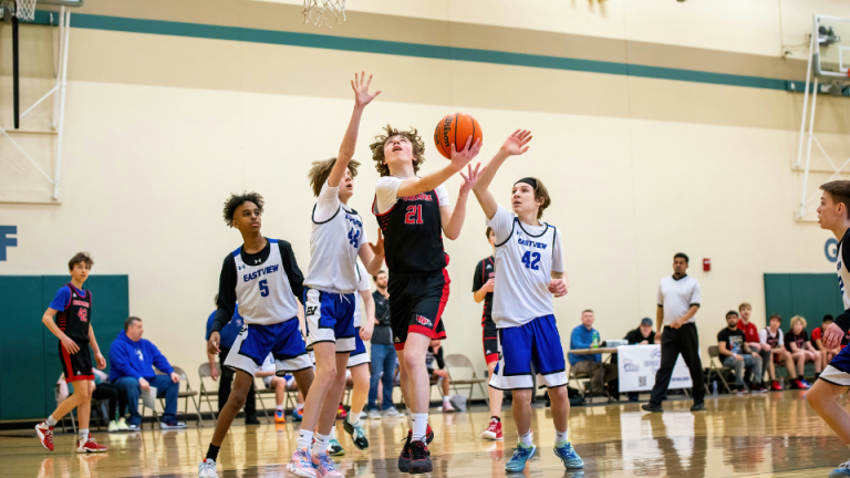 a group of young men playing a game of basketball