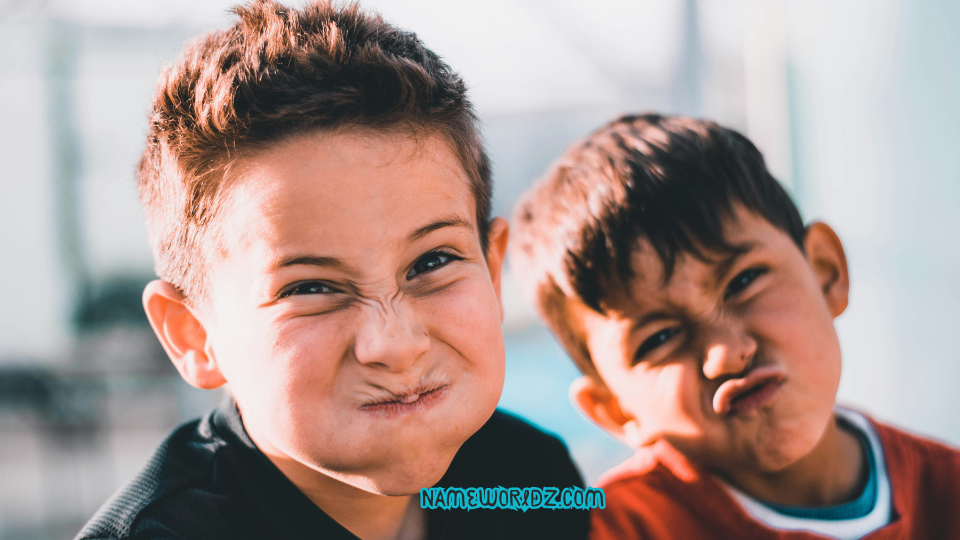 shallow focus photography of two boys doing wacky faces