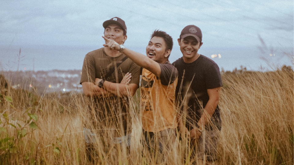 male friends standing on pampas grass