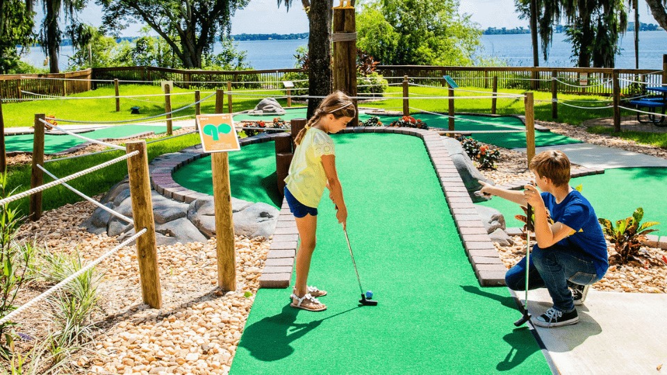 Two siblings playing mini golf