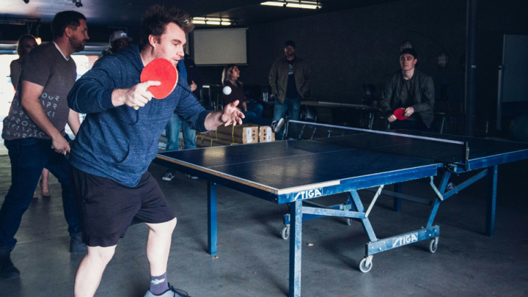 a man holding a ping pong paddle in his hand